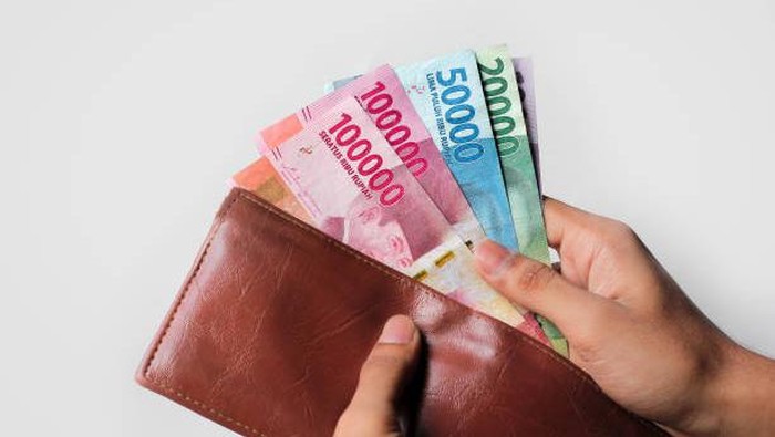 hand showing rupiah money from wallet isolated on white background