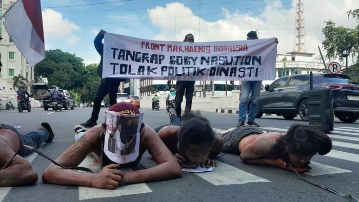 Massa berdemonstrasi di depan Kantor Wali Kota Medan dengan membawa poster Bobby Nasution bersalaman dengan AGK