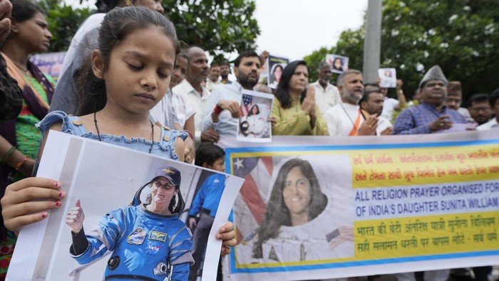 Warga India Doa Bersama untuk Keselamatan Astronot yang Terjebak di ISS A child holds a poster of Sunita Williams as others pray during the all religion prayer for the safe return of American astronaut of Indian origin Sunita Williams and Butch Wilmore from the International Space Station (ISS), in Ahmedabad, India, Sunday, Aug. 25, 2024. (AP Photo/Ajit Solanki)