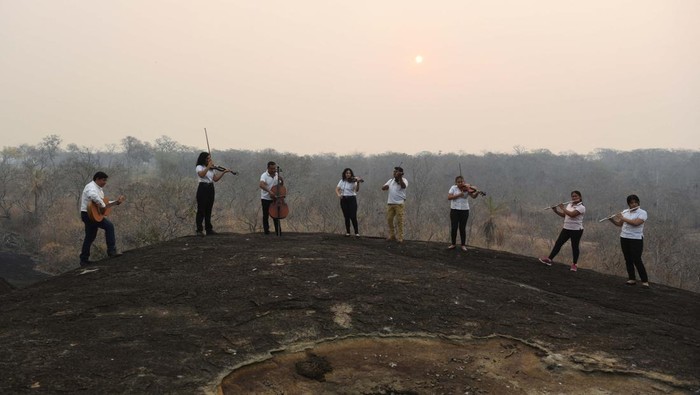 Members of the Misional Padre Martin Schmid Music School play their instruments to bring attention to the smoke from the wildfires in the area, in Concepcion, Bolivia August 26, 2024. REUTERS/Claudia Morales