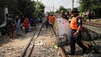 Mereka membongkar gubuk-gubuk liar di sepanjang rel KA.