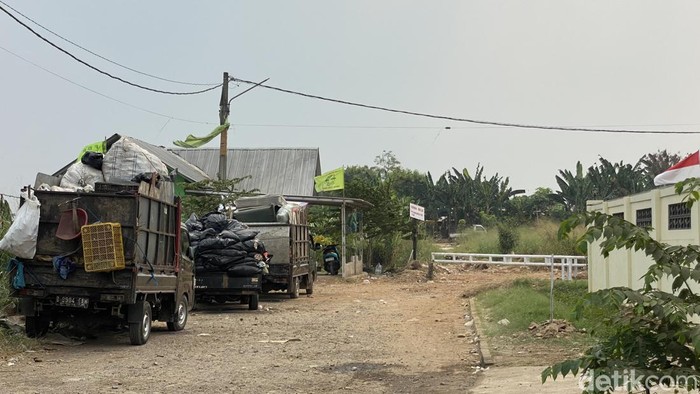 Mobil sampah mengante di depan TPS liar di Limo Depok