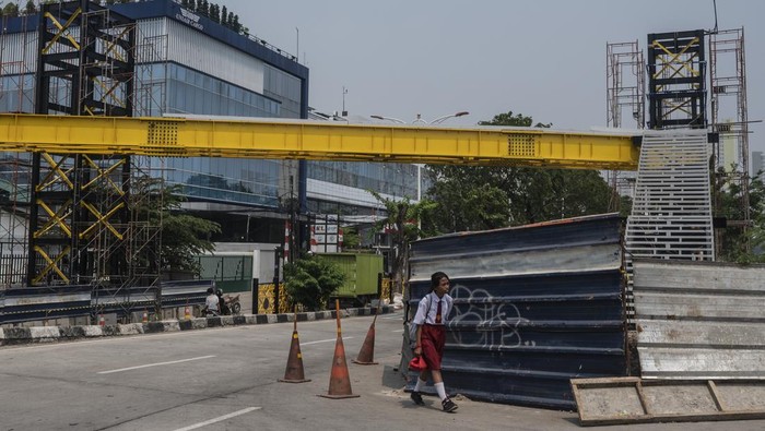 Sejumlah warga berjalan di dekat proyek pembangunan jembatan penyeberangan orang (JPO) di Jalan Danau Sunter Barat, Jakarta, Selasa (27/8/2024). Pemprov DKI Jakarta membangun empat JPO dengan mengusung konsep bernuansa modern diantaranya JPO PGC Cililitan, JPO Sunter Barat, JPO Mas Mansyur, serta JPO Dukuh dan ditargetkan pembangunannya selesai pada November 2024. ANTARA FOTO/Aprillio Akbar/aww.