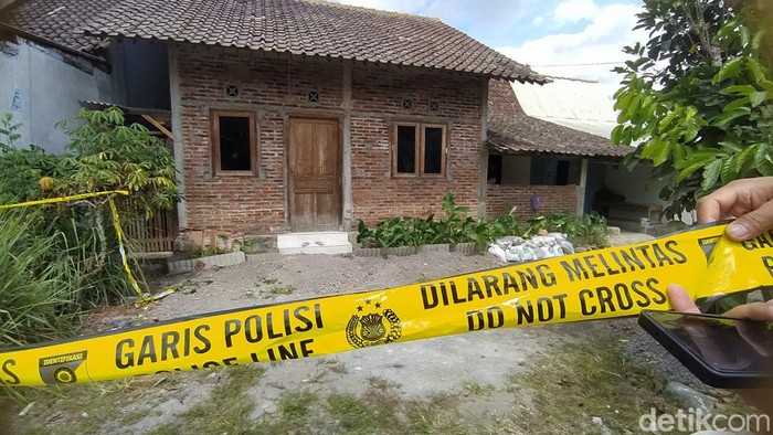 Petugas memasang garis polisi di rumah yang diduga untuk mengoplos miras di Paremono, Mungkid, Magelang, Selasa (27/8/2024).