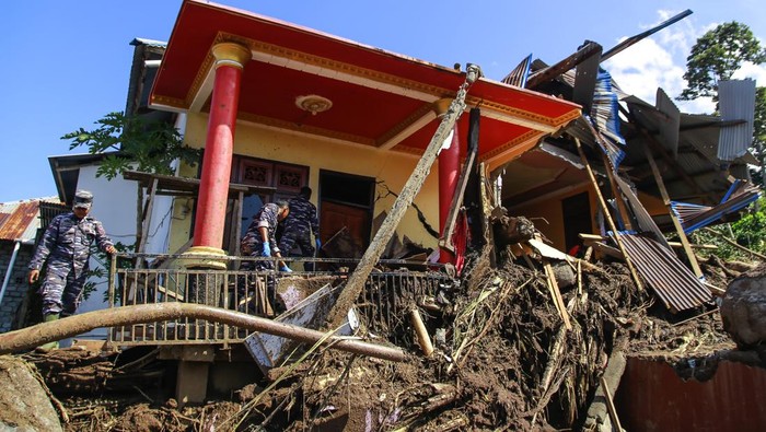 Potret Kerusakan Akibat Banjir Bandang di Ternate, 18 Orang Tewas Sejumlah petugas melintas di dekat rumah yang rusak pasca banjir bandang di Kelurahan Rua, Kota Ternate, Maluku Utara, Selasa (27/8/2024). Badan Penanggulangan Bencana Daerah Kota Ternate mencatat, sebanyak 25 unit rumah warga rusak berat dan satu mushola rusak akibat diterjang banjir bandang yang menewaskan 18 orang. ANTARA FOTO/Andri Saputra/Spt.