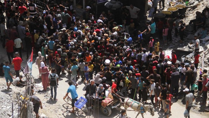 Sedih! Melihat Anak-anak Gaza Antre Makan Palestinians gather to receive food cooked by a charity kitchen, amid Israel-Hamas conflict, near the ruins of houses destroyed during the Israeli offensive, in Jabalia in the northern Gaza Strip August 26, 2024. REUTERS/Mahmoud Issa