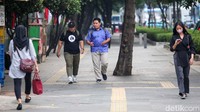 Sejumlah pekerja yang berkantor di kawasan itu terlihat lalu lalang di trotoar Jalan Sudirman.