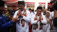 RK-Suswono memakai pakaian baju koko dengan kalungan sarung warna oranye. 