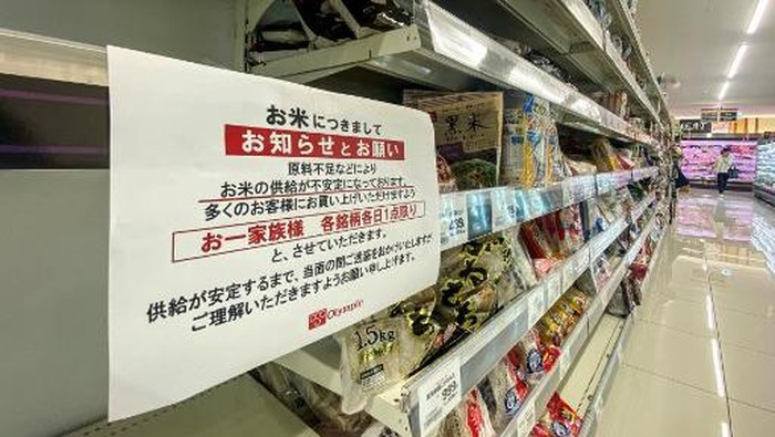 Empty shelves of rice are pictured in a supermarket with a notice written: 