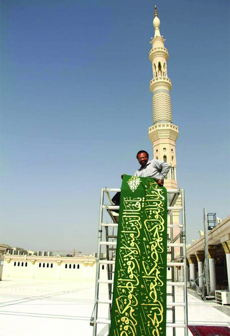 Shafiq Uz-Zaman Khan memegang karya kaligrafinya di Masjid Nabawi