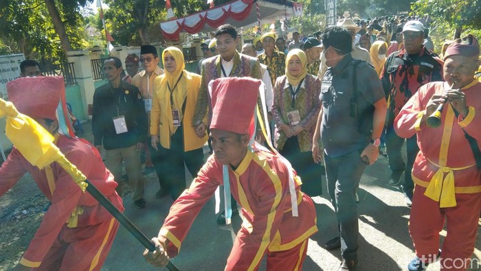 M Putera Ferryandi dan Rostiati (Dae Yandi-Umi Ros) berjalan menuju kantor KPU Kabupaten Bima untuk mendaftar sebagai kontestan Pilbup Bima 2024, Rabu (28/8/2024). (Foto: Rafiin/detikBali)