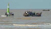 Warga menarik menara adat menggunakan kapal di Pantai Babussalam menjelang pelaksanaan tradisi mandi safar 2024 di Air Hitam Laut, Tanjung Jabung Timur, Jambi, Selasa (27/8/2024). 