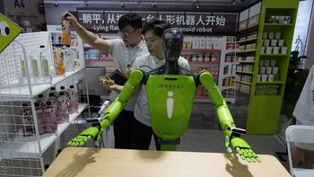 Para pekerja mempersiapkan demonstrasi robot di Konferensi Robot Dunia. AP/Ng Han Guan
