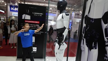 Seorang anak terlihat mencoba berinteraksi dengan robot. AP/Ng Han Guan