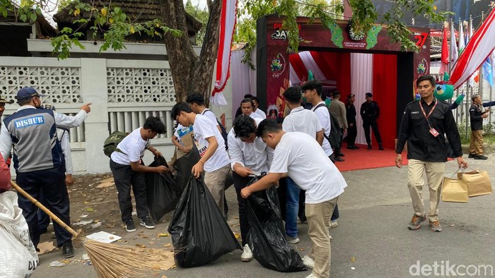 Relawan pendukung Khofifah-Emil langsung bersihkan sisa sampah di sekitar KPU Jatim usai iring-iringan pendaftaran.