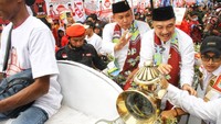 Bakal calon Wali Kota Bekasi Tri Adhianto (kiri) dan bakal calon Wakil Wali Kota Bekasi Harris Bobihoe (kanan) menyapa pendukungnya saat mendaftarkan diri sebagai peserta Pilwalkot Bekasi di Kantor Komisi Pemilihan Umum (KPU) Bekasi, Jawa Barat, Rabu (28/8/2024). 