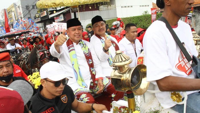 Bakal calon Wali Kota Bekasi Tri Adhianto (kiri) dan bakal calon Wakil Wali Kota Bekasi Harris Bobihoe (kanan) menyapa pendukungnya saat mendaftarkan diri sebagai peserta Pilwalkot Bekasi di Kantor Komisi Pemilihan Umum (KPU) Bekasi, Jawa Barat, Rabu (28/8/2024).