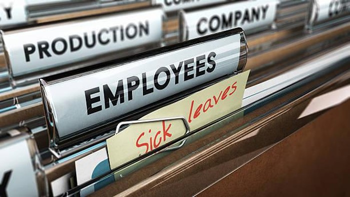 Close up on a file tab with the word employees plus a note with the text sick leaves, blur effect at the background. Concept image for illustration of sick leave entilement.