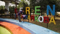 Seorang anak ditemani orangtuanya sedang bermain di RPTRA Sungai Bambu yang berada di kolong tol Wiyoto Wiyono, Tanjung Priok, Jakarta Utara, Kamis (29/8/2024).