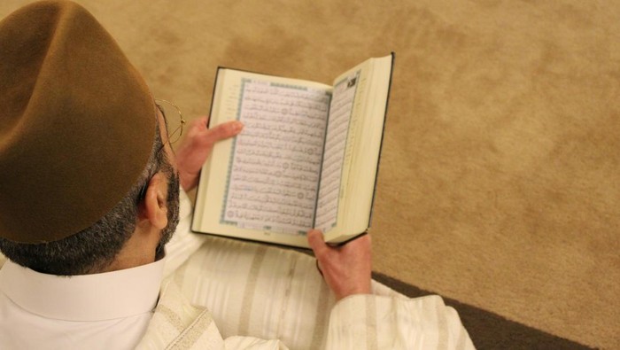 Ilustrasi orang sedang membaca Al-Quran