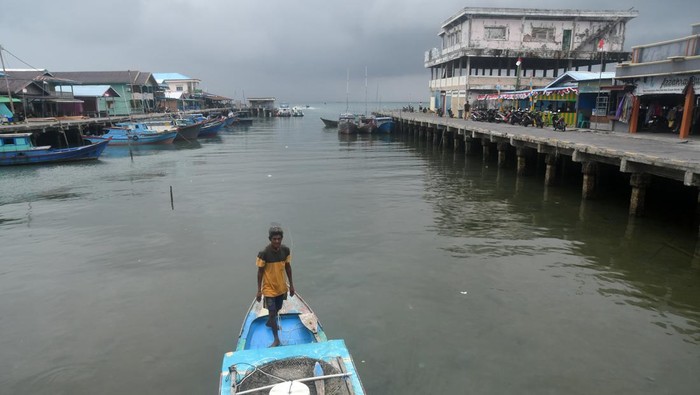 Nelayan berdiri di perahu motornya di Pelabuhan Sedanau, Kabupaten Natuna, Kepulauan Riau, Rabu (28/8/2023). Sejumlah nelayan di kawasan tersebut memilih untuk tidak melaut karena adanya peringatan BMKG tentang cuaca buruk hujan lebat dan waspada ombak tinggi yang dapat mencapai ketinggian dua meter di wilayah perairan Natuna dan Anambas. ANTARA FOTO/Arif Firmansyah/foc.