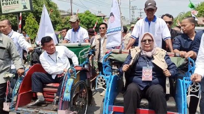 Pasangan Suwarti dan Thamrin Hasan naiki becak menuju kantor KPU Musi Rawas