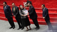 Puan memberikan buku laporan kinerja kepada Ketua DPR periode 2004-2009 Agung Laksono.  