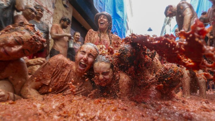Ribuan Orang Semarakkan Perang Tomat Tahunan di Spanyol Revellers throw tomatoes at each other during the annual