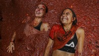 Tomatina konon berasal dari pertikaian spontan di antara penduduk desa pada tahun 1945. Pertunjukan ini sempat dilarang selama tahun 1950-an pada puncak kediktatoran Jenderal Francisco Franco, tetapi tetap populer di seluruh Spanyol pada tahun 1980-an dan kini menarik banyak pengunjung dari luar negeri maupun warga Spanyol. AP/Alberto Saiz 