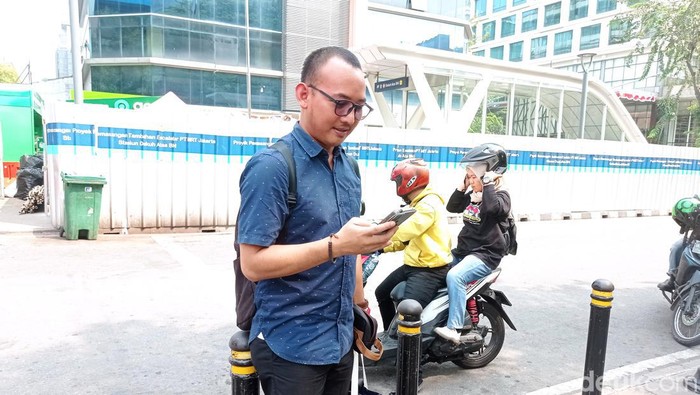 Rino (34) mengeluh sulit dapat driver ojol jelang demo ojol dan kurir hari ini (Taufiq S/detikcom)