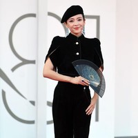 Zhang Ziyi tampil beda mengenakan setelan blouse dan celana serba hitam. Kipas dan topi melengkapi busananya. Foto: Getty Images/Elisabetta A. Villa