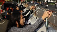 Sejumlah aktivis melakukan aksi simbolik menggembok barikade beton di depan Kedubes AS, Jakarta, Jumat (30/8/2024).