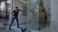 Seorang nasabah menghancurkan kaca depan cabang Emirates Lebanese Bank di Dawra, Beirut, Lebanon, Kamis (29/8/2024).