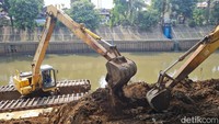 Petugas melakukan pengurakan sedimentasi di Kali Ciliwung, Kebon Baru, Jakarta Selatan, Jumat (30/8/2024).  