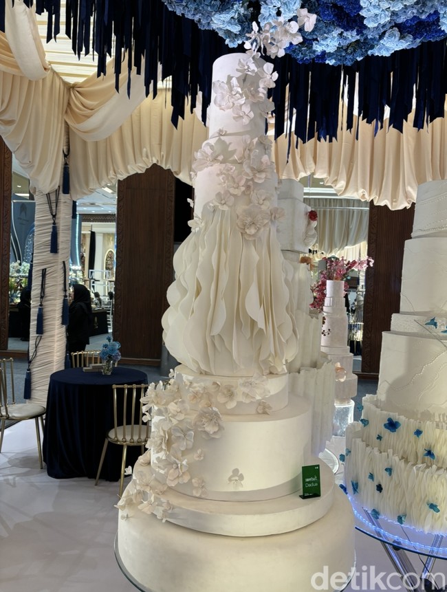 Kue pengantin yang artistik juga jadi tren di tahun 2024. Kalau sekarang yang kita lihat itu bukan fokus ke banyaknya bunga. Kalau zaman dulu kan semakin banyak bunga semakin bagus, kalau sekaraang mungkin lebih ke tekstur, ke bentuk badan, yang nggak common gitu, kayak geometri campur atasnya bulat atau kotak, terang Sherly dari SweetSalt Wedding Cake. Foto: Vina Oktiani/Wolipop