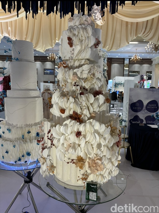 Bagi pasangan yang ingin kue pengantinnya terlihat sedikit lebih heboh namun tetap elegan. Kue pengantin dari SweetSalt Wedding Cake yang satu ini bisa jadi inspirasi. Dengan dipenuhi tekstur membuat kue pengantin jadi terlihat lebih heboh. Namun dengan perpaduan warna putih dan sedikit warna coklat mempertahankan desain elegan dan classy dari kue pengantin tersebut. Foto: Vina Oktiani/Wolipop