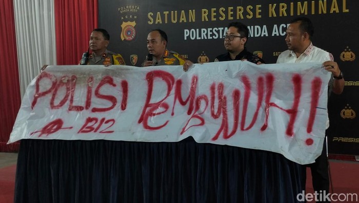 Polisi menunjukkan spanduk yang dipasang oleh mahasiswa di Aceh