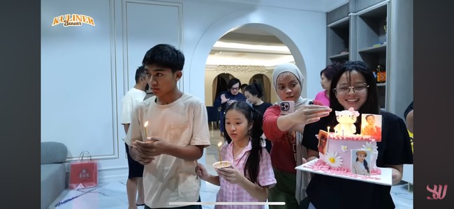 Terlihat kue ulang tahun Sarwendah itu berwarna merah muda dengan tema Hello Kitty. Ada beberapa foto Sarwendah tertempel di kue ultah tersebut. Foto: YouTube/Sarwendah Official