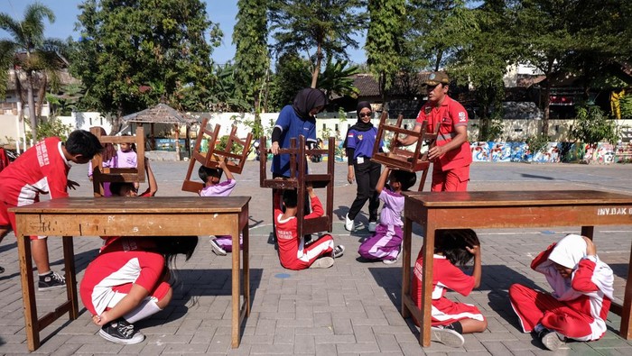 Sejumlah siswa mengikuti simulasi penanganan gempa bumi yang diselenggarakan civitas Politeknik Akbara PMI Solo di Sekolah Dasar Negeri Sabrang Lor Solo, Jawa Tengah, Jumat (30/8/2024). Kegiatan tersebut guna meningkatkan kesiapsiagaan dan kemampuan siswa maupun guru pada penanganan bencana gempa bumi. ANTARAFOTO/Maulana Surya/aww.