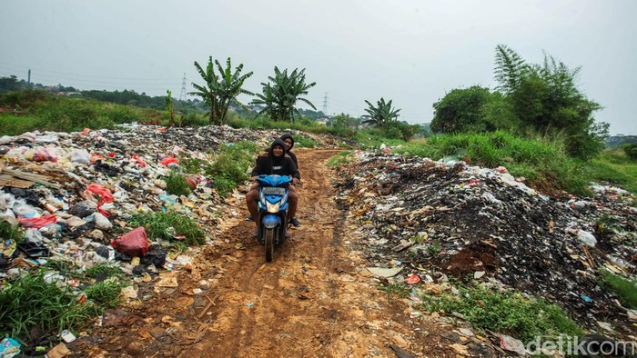 Pengendara motor melintas di Kawasan Tanah Merah, Depok, Jumat (30/8/2024). Tanah merah menjadi kawasan perbatasan kota Depok dengan Bojong Gede, hamparan tanah luas tersebut kini digunakan menjadi Tempat Pembuangan Sampah (TPS) dadakan.