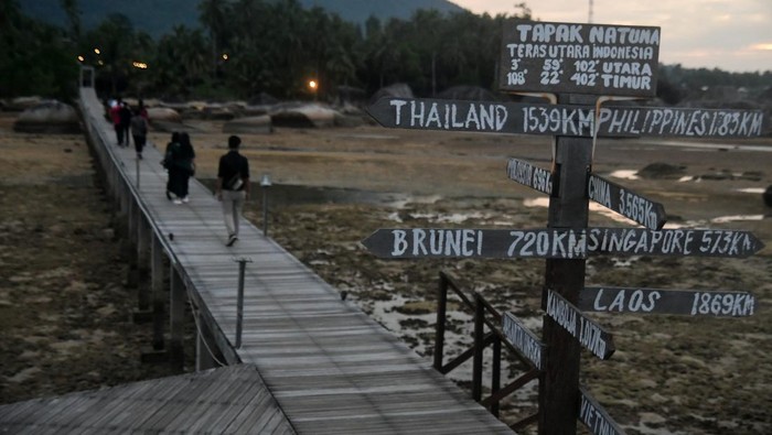 Wisata Tapak Natuna di Kepulauan Riau Wisatawan berjalan di jembatan kayu sepanjang 200 meter saat berwisata di Tapak Natuna, Kepulauan Riau, Kamis (29/8/2024). Wisata Tapak Natuna atau Teras Utara Indonesia merupakan lanskap alami dari bebatuan granit raksasa yang terletak di atas laut dan ditandai dengan marka penunjuk perbatasan antara delapan negara yang menjadi salah satu ikon unik Pulau Natuna. ANTARA FOTO/Arif Firmansyah/tom.