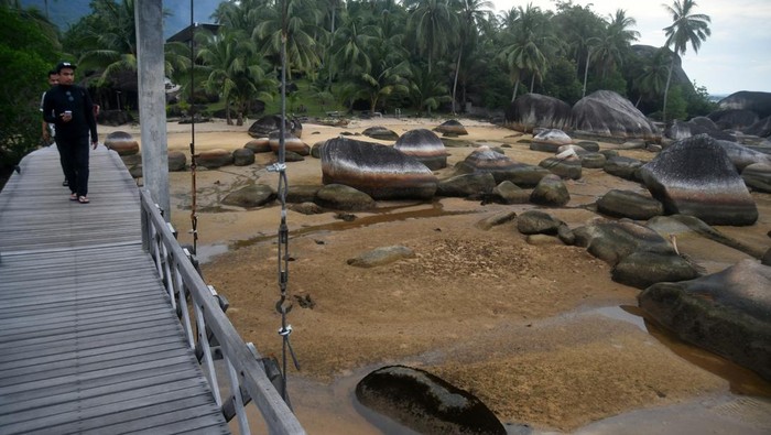 Wisatawan berjalan di jembatan kayu sepanjang 200 meter saat berwisata di Tapak Natuna, Kepulauan Riau, Kamis (29/8/2024). Wisata Tapak Natuna atau Teras Utara Indonesia merupakan lanskap alami dari bebatuan granit raksasa yang terletak di atas laut dan ditandai dengan marka penunjuk perbatasan antara delapan negara yang menjadi salah satu ikon unik Pulau Natuna. ANTARA FOTO/Arif Firmansyah/tom.