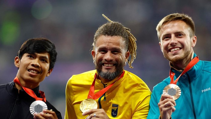 Paris 2024 Paralympics - Athletics - Men's 100m - T37 Final - Stade de France, Saint-Denis, France - August 30, 2024 Ricardo Gomes de Mendonca of Brazil crosses the finish line to win gold followed by Saptoyogo Purnomo of Indonesia and Andrei Vdovin of Neutral Paralympic Athletes REUTERS/Stephanie Lecocq