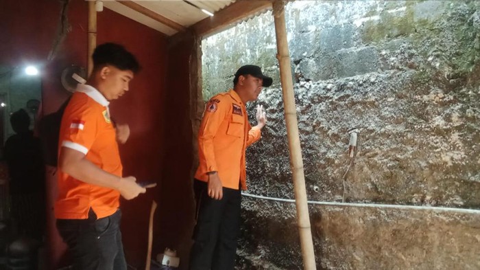 Petugas mengecek rumah warga yang rusak akibat hujan dan angin kencang