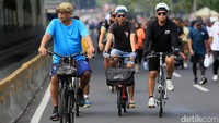 Beberapa pesepeda terlihat melintas di antara warga yang berolahraga di kawasan Bundaran HI.