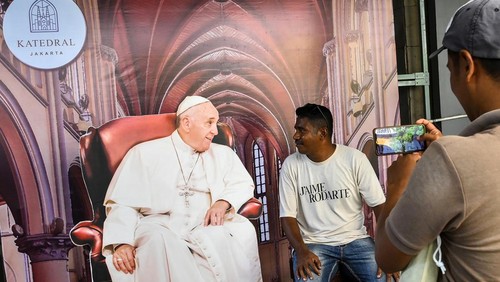 Warga berfoto dengan dekorasi bergambar Paus Fransiskus yang terpasang di Gereja Katedral Jakarta, Sabtu (31/8/2024). Gereja Katedral Jakarta menyiapkan dekorasi khusus untuk menyambut kunjungan Paus Fransiskus ke Indonesia pada 3-6 September 2024 dan mengunjungi Katedral pada 4 September 2024. ANTARA FOTO/Sulthony Hasanuddin/Spt.