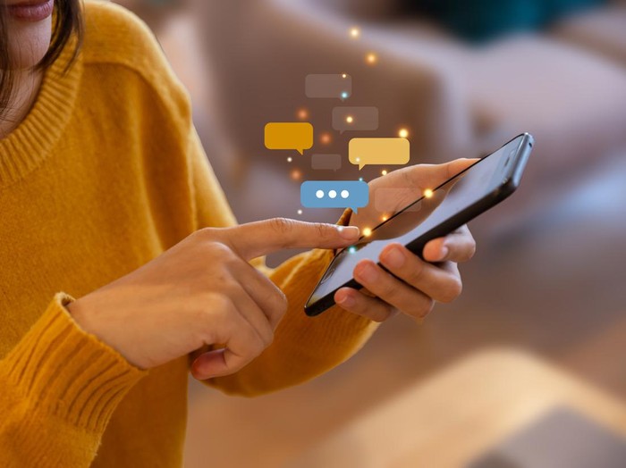 Hand of young woman using smartphone for chat and communication. Digital media website and social network.