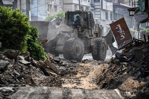 An Israeli bulldozer tears up a street as members of the press film during an Israeli raid in the occupied West Bank city of Jenin on September 1, 2024. (Photo by RONALDO SCHEMIDT / AFP)