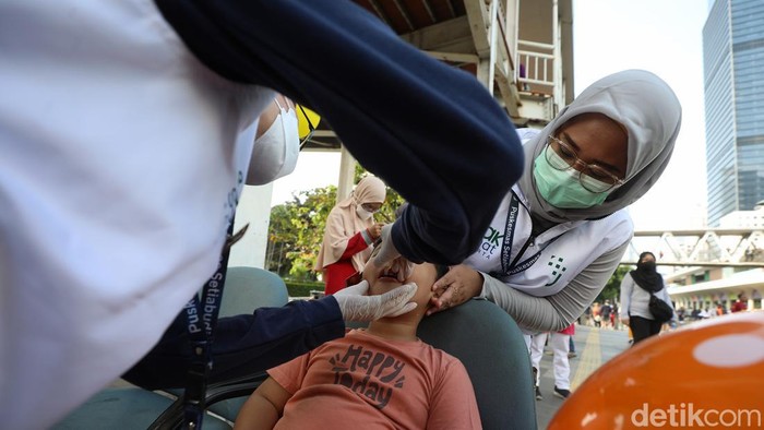 Petugas kesehatan memberikan vaksin polio kepada anak saat car free day di Jalan Jenderal Sudiman, Jakarta, Minggu (1/9/2024).