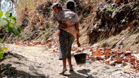 Setelah mengisi ember dengan air, mereka terlihat bersusah payah membawanya pulang ke rumah.